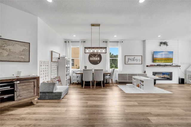 living room with hardwood / wood-style floors, a notable chandelier, and a textured ceiling