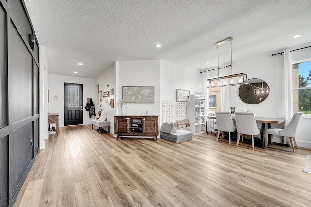 living room featuring light wood-type flooring and a textured ceiling