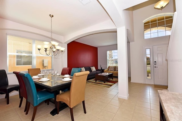 dining area with light tile patterned floors and a chandelier