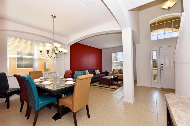 401 Cabello Dr, Davenport, FL 33837 - dining area with a chandelier, arched walkways, light tile patterned flooring, and baseboards