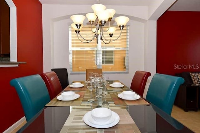 dining space featuring tile patterned flooring and a chandelier