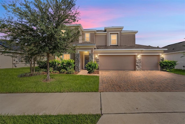 prairie-style home with a garage and a yard