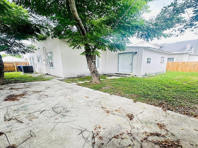 exterior space with central AC and a lawn