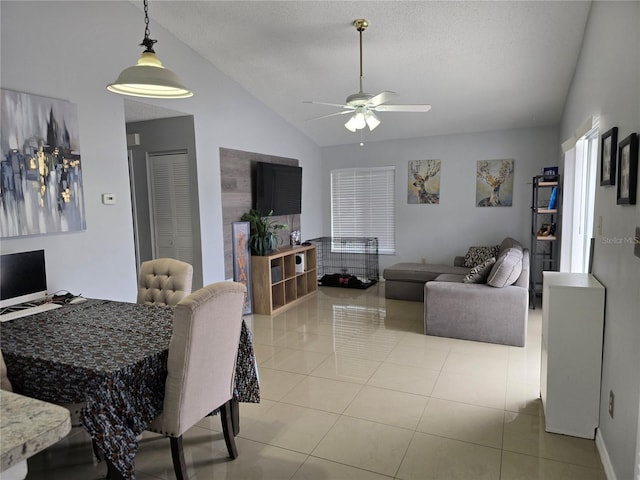 living room with ceiling fan, light tile patterned floors, and vaulted ceiling