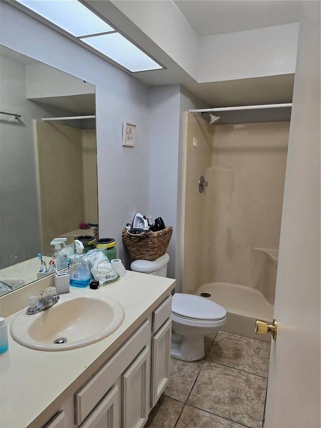 bathroom with vanity, toilet, walk in shower, and tile patterned flooring