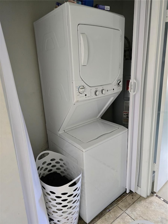 washroom featuring light tile patterned floors and stacked washer and dryer