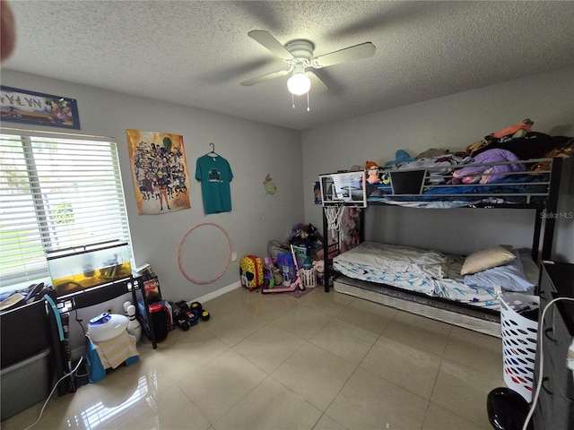 tiled bedroom with ceiling fan and a textured ceiling