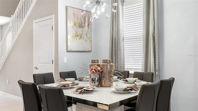 tiled dining room featuring an inviting chandelier