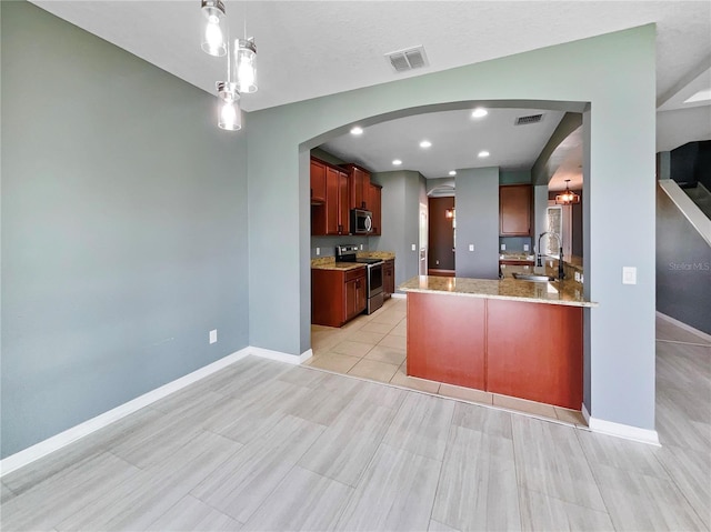 kitchen featuring stainless steel appliances, a peninsula, a sink, and visible vents