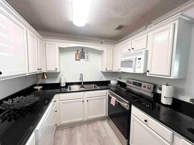 kitchen with sink, white cabinets, and white appliances