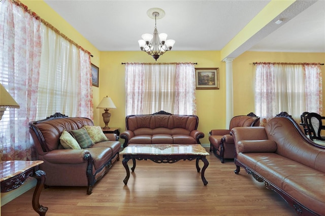 living room featuring plenty of natural light, hardwood / wood-style flooring, and ornate columns