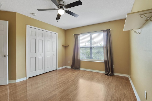 unfurnished bedroom featuring a textured ceiling, ceiling fan, a closet, and light hardwood / wood-style floors