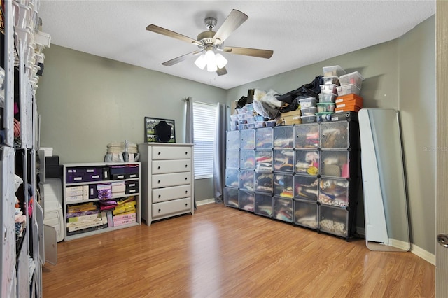 interior space with ceiling fan, a textured ceiling, and light hardwood / wood-style flooring