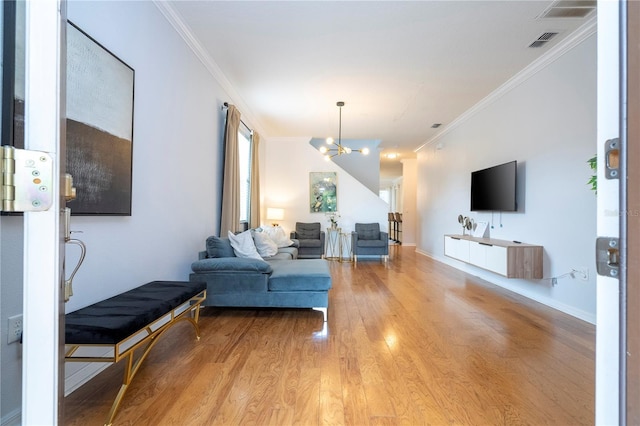 living room with an inviting chandelier, light hardwood / wood-style flooring, and ornamental molding