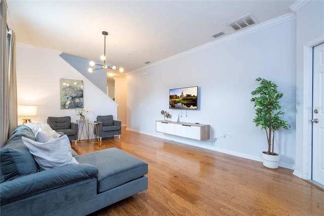 living room featuring a chandelier, ornamental molding, and wood-type flooring