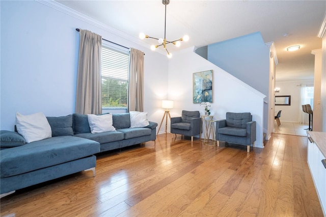 living room with light hardwood / wood-style floors, an inviting chandelier, and ornamental molding