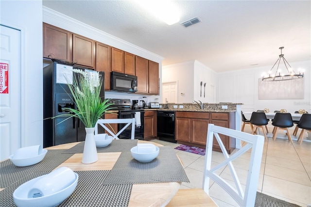 kitchen featuring light tile patterned floors, a notable chandelier, pendant lighting, and black appliances