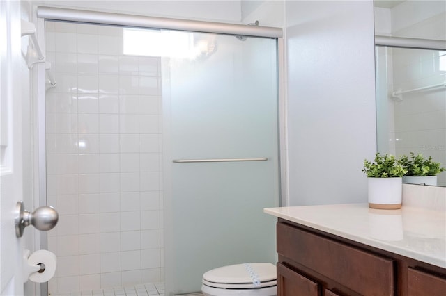 bathroom featuring an enclosed shower, vanity, and toilet