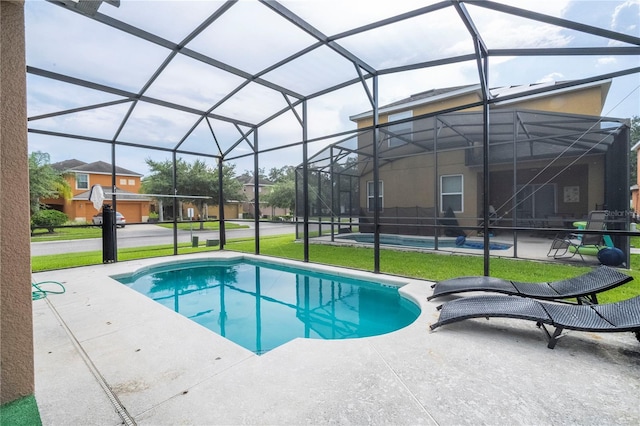 view of swimming pool with a patio, a lanai, and a lawn