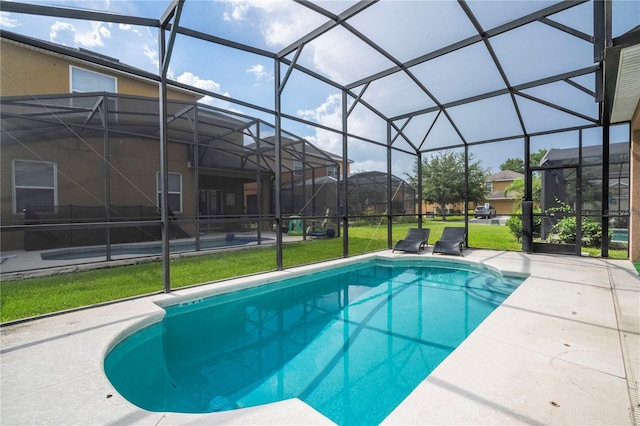 view of swimming pool featuring a patio, a yard, and a lanai