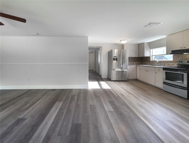 kitchen with ceiling fan, sink, decorative backsplash, appliances with stainless steel finishes, and hardwood / wood-style flooring