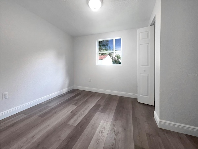 spare room featuring dark wood-type flooring