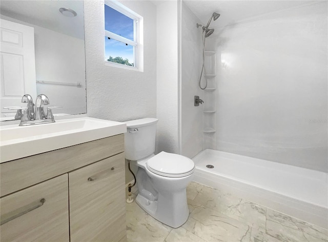 bathroom with vanity, toilet, and a shower