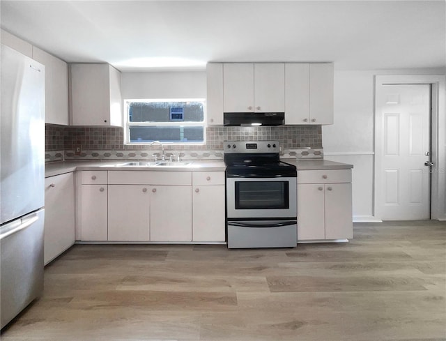 kitchen with white cabinetry, sink, backsplash, light hardwood / wood-style floors, and appliances with stainless steel finishes