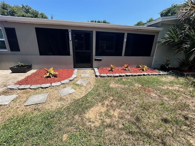 property entrance with a lawn