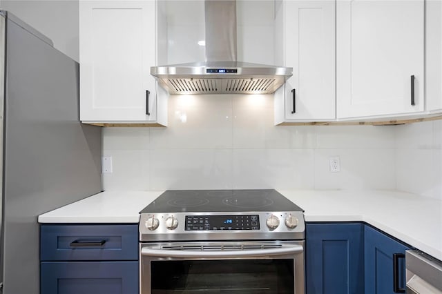 kitchen with blue cabinetry, tasteful backsplash, stainless steel appliances, and ventilation hood