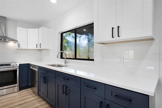 kitchen featuring a sink, white cabinets, light countertops, stainless steel electric range, and wall chimney exhaust hood