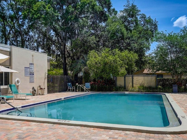 community pool featuring fence and a patio