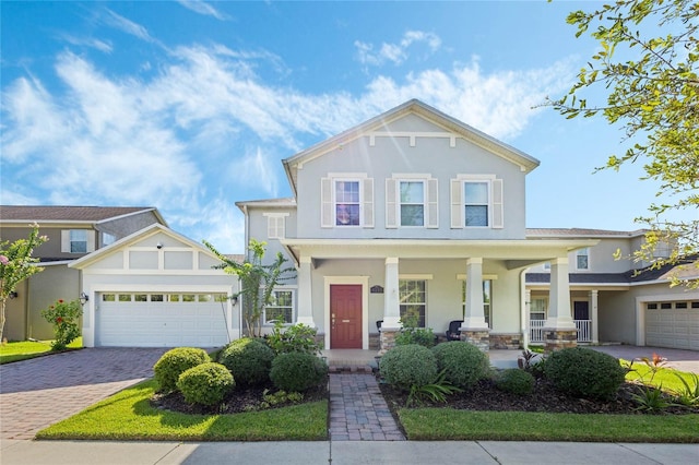 view of front of property with a porch, decorative driveway, an attached garage, and stucco siding