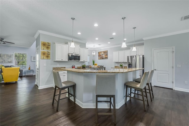 kitchen with a spacious island, a kitchen bar, stainless steel appliances, and dark wood-type flooring