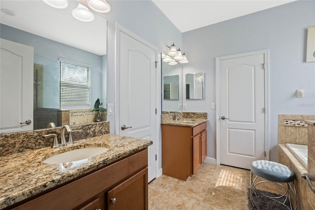 full bath with two vanities, a relaxing tiled tub, a sink, and tile patterned flooring