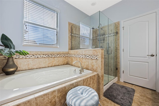 bathroom with a healthy amount of sunlight, a garden tub, a shower stall, and tile patterned floors