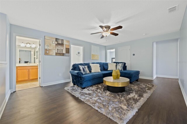 living room featuring ceiling fan and dark hardwood / wood-style floors