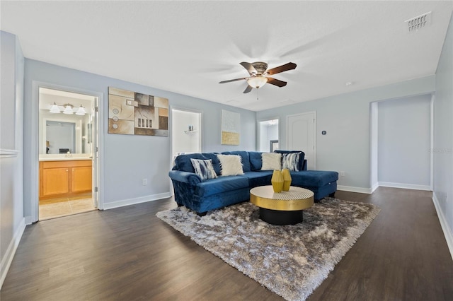 living room with baseboards, visible vents, ceiling fan, and dark wood-style flooring