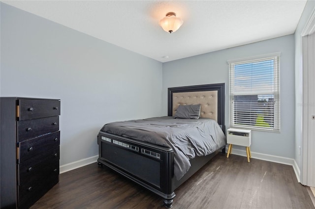 bedroom featuring baseboards and wood finished floors