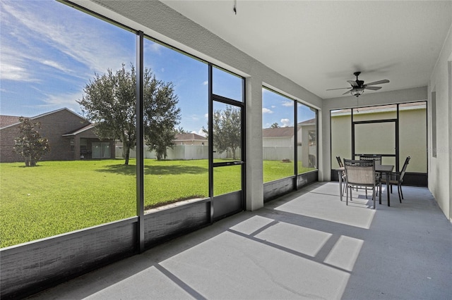 unfurnished sunroom with ceiling fan