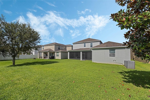 back of house featuring a lawn, fence, a sunroom, and central air condition unit