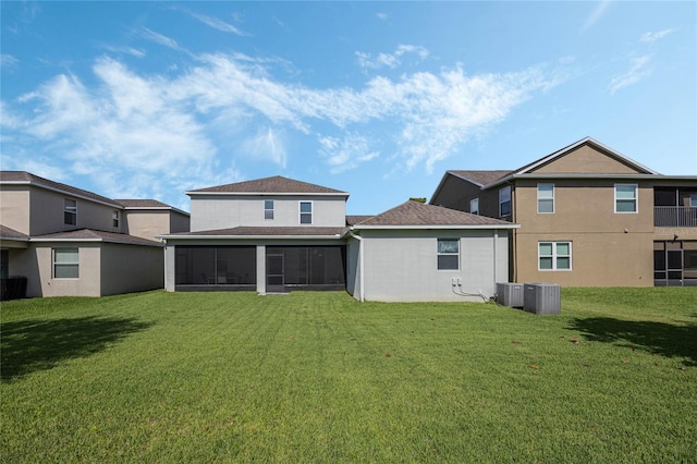 rear view of house with a lawn, cooling unit, a sunroom, and stucco siding