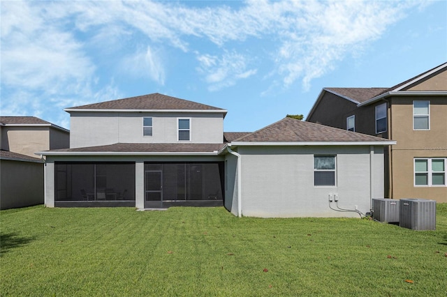 rear view of house with central AC, a yard, and a sunroom