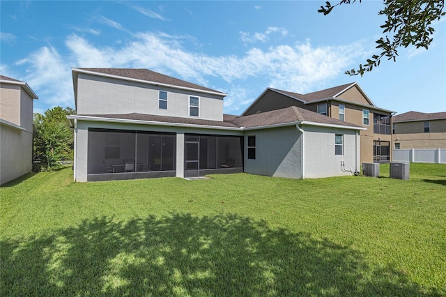 rear view of property featuring a sunroom, a lawn, and central air condition unit