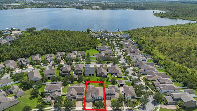 aerial view featuring a water view, a wooded view, and a residential view