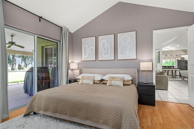 bedroom with light wood-type flooring, vaulted ceiling, and access to exterior