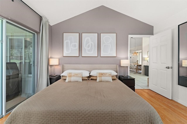 bedroom with vaulted ceiling, wood-type flooring, and access to outside