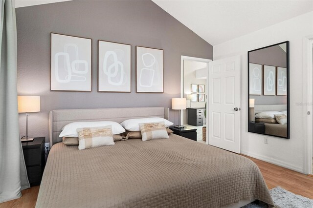 bedroom with light hardwood / wood-style flooring and lofted ceiling