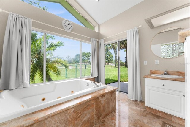 bathroom with vaulted ceiling, a relaxing tiled tub, and vanity