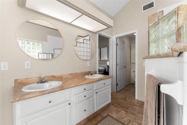 bathroom featuring vaulted ceiling, vanity, and toilet